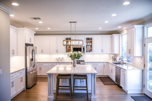 pexels-photo-2724749-2724749 Spacious and elegant kitchen featuring white cabinetry, island, and stainless steel appliances.